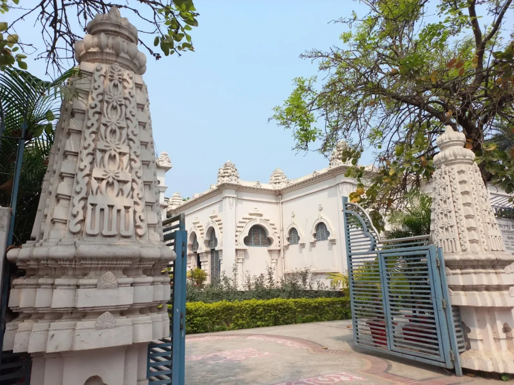 An interior view of a gallery at the Varendra Research Museum, with stone sculptures displayed in glass cases.