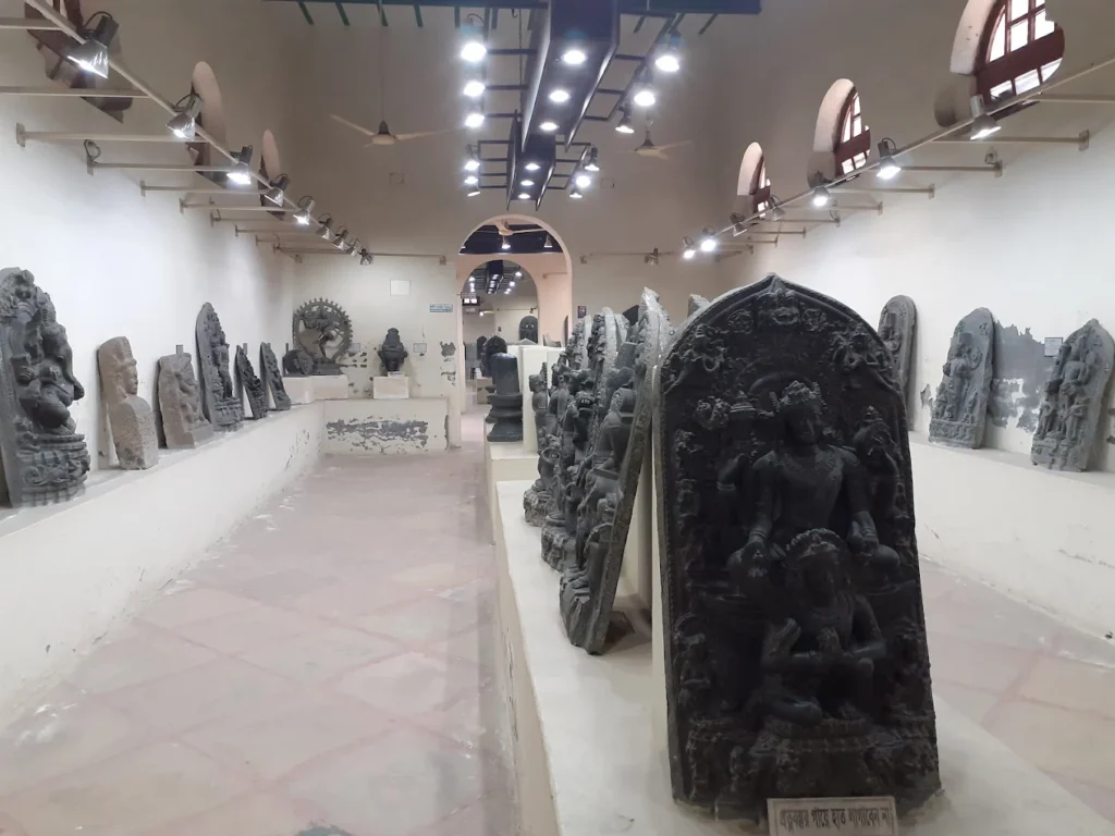 A detailed 11th-century black basalt statue of Surya, a highlight of the Varendra Research Museum's sculpture collection.