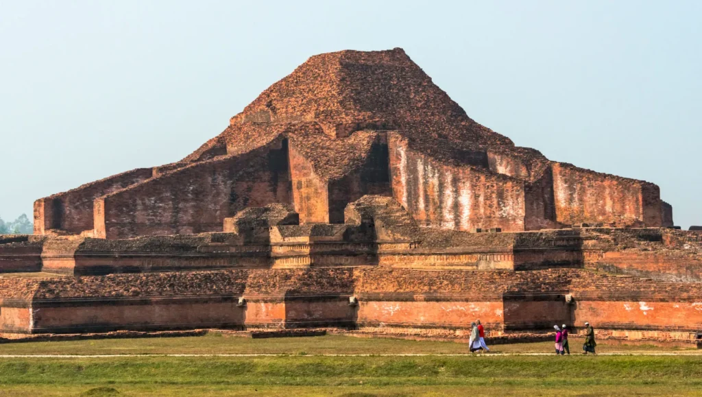 The ancient terracotta brick central temple of Somapura Mahavihara in Paharpur, Bangladesh, under a blue sky.